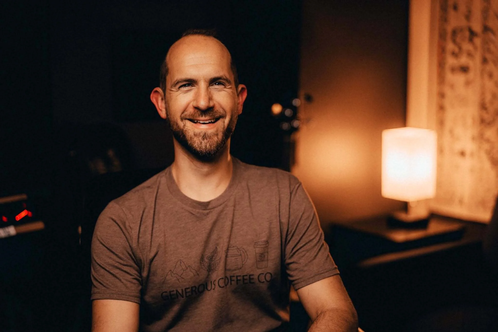 Drew Scholl smiling in a warmly lit room